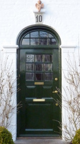 Kapitæler og topsten (med påmalet husnr.) er overmalet i facadens farve. Døren har været fuldstændig adskilt og repareret - Foto: Kurt Smith