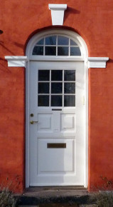 Kapitæler og topstykke malet i dørens farve som danner kontrast til facadefarven - Foto: Kurt Smith